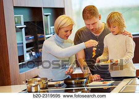 Stock Photography - Family in the kitchen. Three generations. Healthy eating. Healthy growth. Cooking fish and vegetable skewer.. Fotosearch