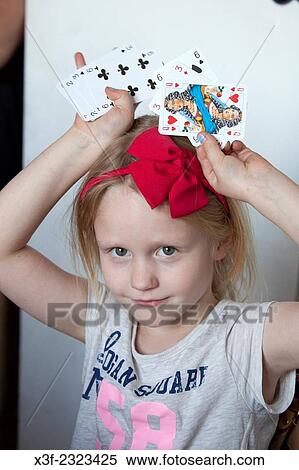 Girl age 6 holding playing cards over her head. Lodz Central Poland. View Large Photo Image Stock Photography - Girl age 6 holding playing cards over her head. Lodz Central Poland.. Fotosearch