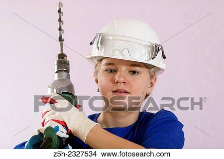 Girl in working clothes with construction tools. View Large Photo Image Picture - Girl in working clothes with construction tools.. Fotosearch