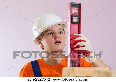 Stock Image - Girl in working clothes with construction tools.. Fotosearch