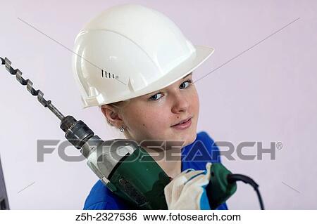 Stock Photograph - Girl in working clothes with construction tools.. Fotosearch