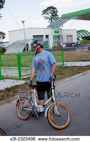Helmeted man age 38 holding a small child's bicycle. Rzeczyca Poland. View Large Photo Image Stock Photo - Helmeted man age 38 holding a small child's bicycle. Rzeczyca Poland.. Fotosearch