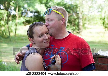 Loving man embracing and kissing his happy wife. Zawady Central Poland. View Large Photo Image Picture - Loving man embracing and kissing his happy wife. Zawady Central Poland.. Fotosearch