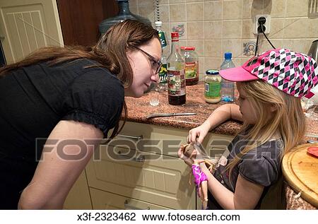 Stock Image - Mom has serious discussion with daughter in the kitchen age 34 and 6. Zawady Central Poland.. Fotosearch