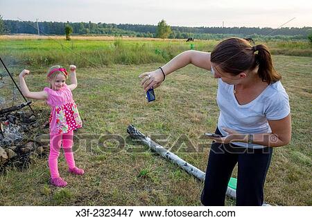 Mom photographs daughter at Polish family grill age 6 and 34. Zawady Central Poland. View Large Photo Image Stock Photo - Mom photographs daughter at Polish family grill age 6 and 34. Zawady Central Poland.. Fotosearch