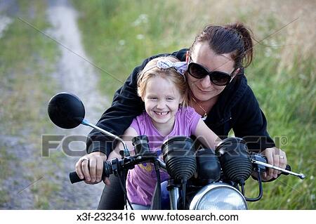 Mother riding on motorcycle with excited young daughter age 34 and 6. Zawady Central Poland. View Large Photo Image Stock Photograph - Mother riding on motorcycle with excited young daughter age 34 and 6. Zawady Central Poland.. Fotosearch