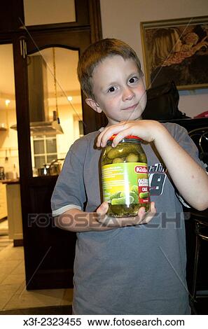 Stock Photography - Polish boy age 10 holding a large jar of pickles, his favorite food. Zawady Central Poland.. Fotosearch