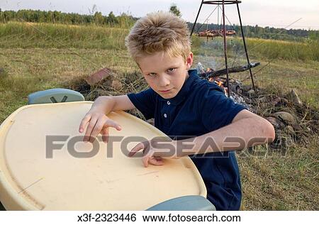 Polish boy age 10 plays drums on children's table during a family barbecue. Zawady Central Poland. View Large Photo Image Stock Photograph - Polish boy age 10 plays drums on children's table during a family barbecue. Zawady Central Poland.. Fotosearch