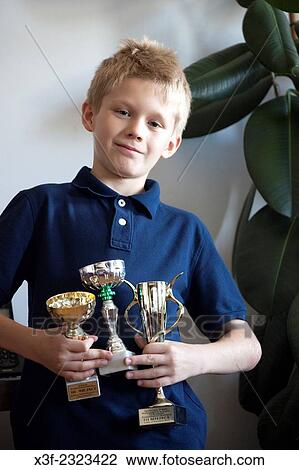 Polish boy age 10 proudly holds his trophies for violin playing at a Concert of Chamber Music for Children. Lodz Central Poland. View Large Photo Image Stock Image - Polish boy age 10 proudly holds his trophies for violin playing at a Concert of Chamber Music for Children. Lodz Central Poland.. Fotosearch