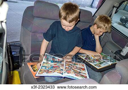 Polish boys age 10 and 8 totally adsorbed reading newly acquired comic books in back of family van. Lodz Central Poland. View Large Photo Image Stock Image - Polish boys age 10 and 8 totally adsorbed reading newly acquired comic books in back of family van. Lodz Central Poland.. Fotosearch