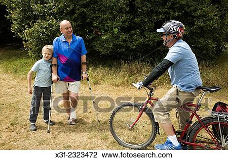 Polish grandfather on arm crutches talking to his bike crazed American son-in-law - three generations. Zawady Central Poland. View Large Photo Image Stock Image - Polish grandfather on arm crutches talking to his bike crazed American son-in-law - three generations. Zawady Central Poland.. Fotosearch
