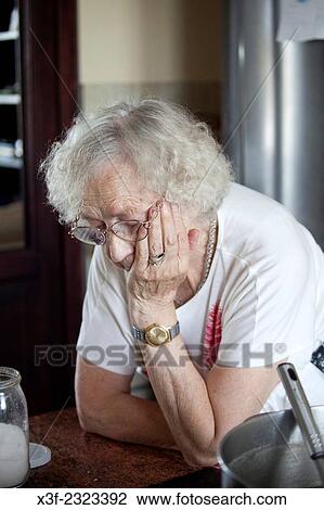 Stock Image - Polish great grandmother age 88 in her kitchen deep in thought. Zawady Central Poland.. Fotosearch