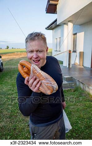 Polish man age 39 licking his chops over newly purchased kielbasa sausage. Zawady Central Poland. View Large Photo Image Picture - Polish man age 39 licking his chops over newly purchased kielbasa sausage. Zawady Central Poland.. Fotosearch