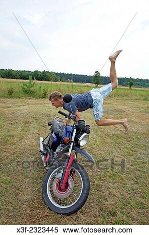 Polish teen boy performing acrobatic moves on his motorcycle. Zawady Central Poland. View Large Photo Image Stock Photography - Polish teen boy performing acrobatic moves on his motorcycle. Zawady Central Poland.. Fotosearch