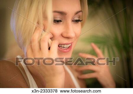 Stock Photo - Pretty blonde woman talking on cell phone.. Fotosearch