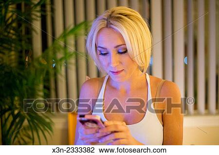 Pretty blonde woman texting on cell phone. View Large Photo Image Stock Image - Pretty blonde woman texting on cell phone.. Fotosearch