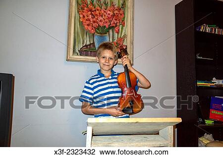 Proud Polish boy age 10 holds his violin during a practice session at home. Zawady Central Poland. View Large Photo Image Stock Image - Proud Polish boy age 10 holds his violin during a practice session at home. Zawady Central Poland.. Fotosearch