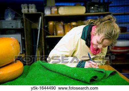 Rotterdam, Netherlands. A young woman, working in a marketstall, selling Dutch cheese, writing a note. View Large Photo Image Stock Image - Rotterdam, Netherlands. A young woman, working in a marketstall, selling Dutch cheese, writing a note.. Fotosearch