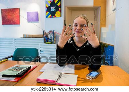 Picture - Rotterdam, Netherlands. Young, blonde female showing of her newly painted nails.. Fotosearch