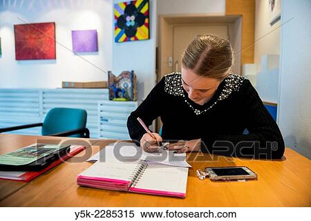 Rotterdam, Netherlands. Young, blonde female making notes during her internship at an art gallery. View Large Photo Image Stock Photography - Rotterdam, Netherlands. Young, blonde female making notes during her internship at an art gallery.. Fotosearch
