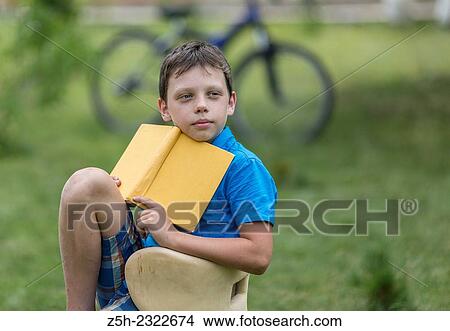 Teen twelve years in the garden with a book. View Large Photo Image Picture - Teen twelve years in the garden with a book.. Fotosearch