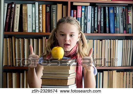 Picture - The girl with green apple and a book.. Fotosearch