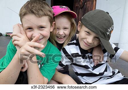 Three Polish siblings having fun mugging for the camera. Zawady Central Poland. View Large Photo Image Stock Photograph - Three Polish siblings having fun mugging for the camera. Zawady Central Poland.. Fotosearch