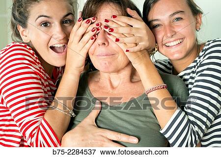 Two young girls covering the eyes to her mother for a surprise View Large Photo Image Stock Photo - Two young girls covering the eyes to her mother for a surprise. Fotosearch