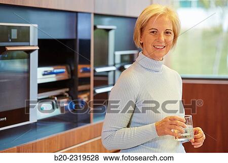 Woman drinking water in the kitchen. View Large Photo Image Stock Photo - Woman drinking water in the kitchen.. Fotosearch