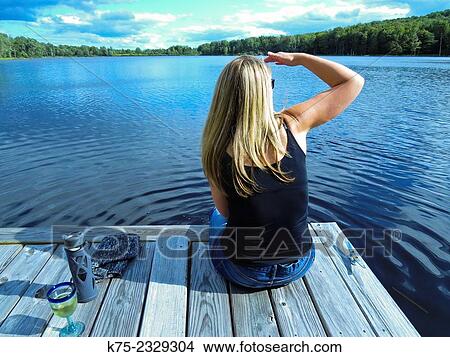Woman on dock looking out over lake View Large Photo Image Picture - Woman on dock looking out over lake. Fotosearch