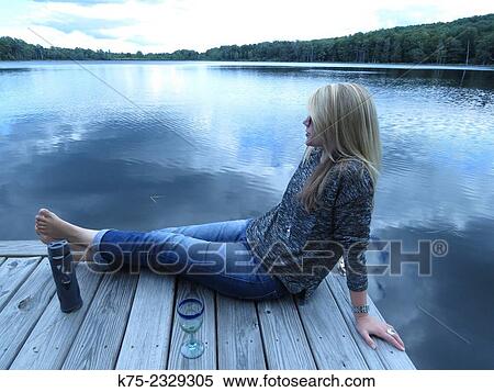 Woman sitting on dock at lake relaxing View Large Photo Image Stock Photography - Woman sitting on dock at lake relaxing. Fotosearch