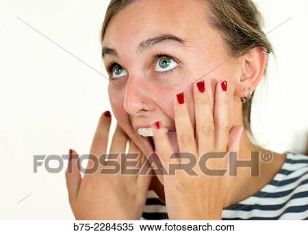 Young blonde woman with wide eyes open and hands on her face with surprised expression. View Large Photo Image Stock Photography - Young blonde woman with wide eyes open and hands on her face with surprised expression.. Fotosearch
