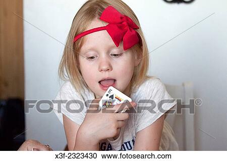 Young girl age 6 deeply engrossed in a game of cards. Lodz Central Poland. View Large Photo Image Stock Image - Young girl age 6 deeply engrossed in a game of cards. Lodz Central Poland.. Fotosearch