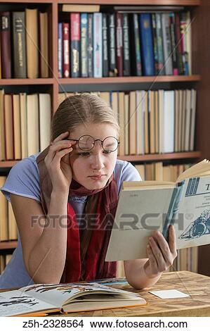 Young girl reading fiction. View Large Photo Image Picture - Young girl reading fiction.. Fotosearch