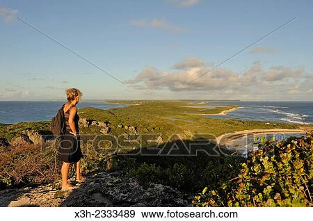 Stock Photo - young woman admiring landscape from the summit of Pointe des Chateaux, Grande-Terre, Guadeloupe, overseas region of France, Leewards Islands, Lesser Antilles, Caribbean.. Fotosearch