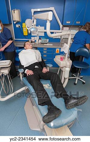 Picture - A 14 year old boy having a tooth extracted at the dentists in the Uk.. Fotosearch