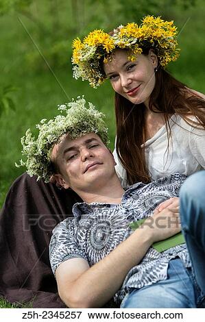 Stock Photo - A man with a girl in a summer park reading a book.. Fotosearch