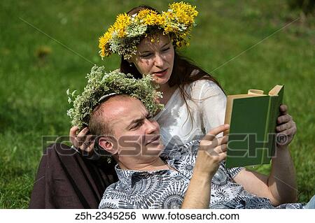 Stock Photograph - A man with a girl in a summer park reading a book.. Fotosearch