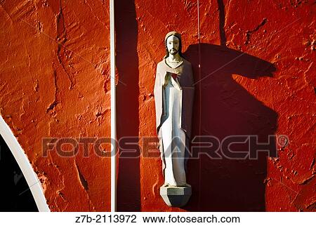 A religious image in a red wall of a house in Great Canary island, Spain. View Large Photo Image Stock Image - A religious image in a red wall of a house in Great Canary island, Spain.. Fotosearch