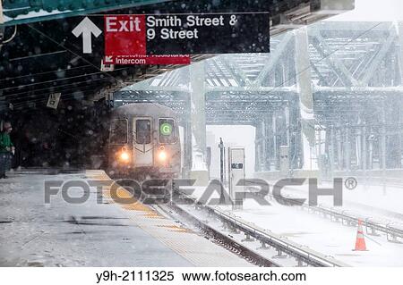 A subway train arrives at the Smith Street-9th Street station on the elevated portion of the IND line in the Gowanus neighborhood of Brooklyn in New York during a snow storm View Large Photo Image Stock Photography - A subway train arrives at the Smith Street-9th Street station on the elevated portion of the IND line in the Gowanus neighborhood of Brooklyn in New York during a snow storm. Fotosearch