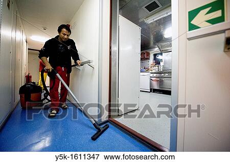 Stock Photo - An Indonesian seaman or sailor on the container-vessel MV Flintercape, during a journey from Rotterdam, Netherlands, to Sundsvall, Sweden. The man is an 'Able Seaman', who generally works on deck, and now cleans the interior of the wheelhouse.. Fotosearch