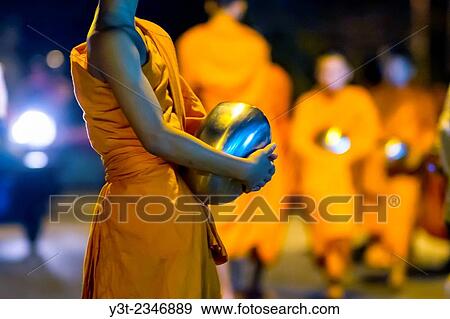 Stock Photo - Asia. Thailand, Chiang Mai. Young Buddhist monks on their morning procession for offerings of food near a monastery in the Huay Kaew area.. Fotosearch