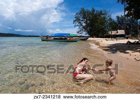 Beach on the island of Koh Russei. Cambodia. Travel with children's. Mother playing with her daughter. Koh Russei, also named Koh Russey or Bamboo Island is a green, gilt-edged crescent, resting on emerald or blue water. View Large Photo Image Stock Photo - Beach on the island of Koh Russei. Cambodia. Travel with children's. Mother playing with her daughter. Koh Russei, also named Koh Russey or Bamboo Island is a green, gilt-edged crescent, resting on emerald or blue water.. Fotosearch