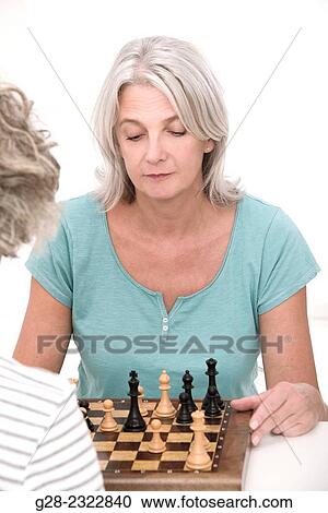 Beautiful mature woman playing chess with another senior woman View Large Photo Image Stock Image - Beautiful mature woman playing chess with another senior woman. Fotosearch