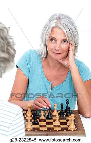 Beautiful mature woman playing chess with another senior woman View Large Photo Image Stock Photography - Beautiful mature woman playing chess with another senior woman. Fotosearch