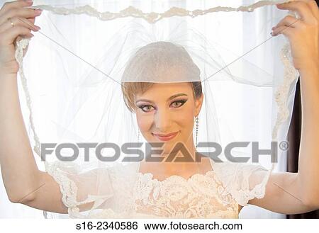 Beautiful young bride holding her veil - Bucharest, Romania, Eastern Europe, Europe. View Large Photo Image Stock Photograph - Beautiful young bride holding her veil - Bucharest, Romania, Eastern Europe, Europe.. Fotosearch