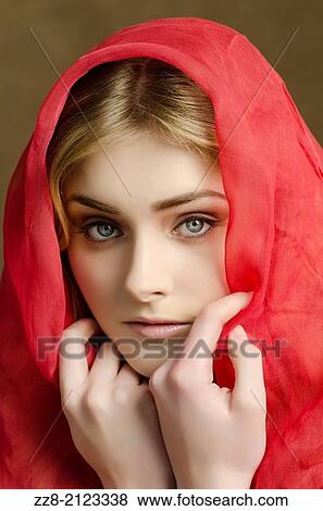 Stock Photo - Beautiful young woman covered with red chiffon scarf.. Fotosearch