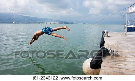 Boy jumping into the sea. Peniscola, Valencian Community, Spain. View Large Photo Image Stock Image - Boy jumping into the sea. Peniscola, Valencian Community, Spain.. Fotosearch