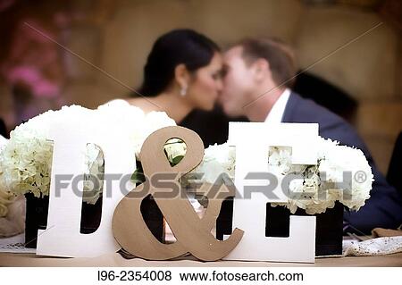 bride and groom kissing at their reception behind big initial signs at their sweetheart table View Large Photo Image Stock Photo - bride and groom kissing at their reception behind big initial signs at their sweetheart table. Fotosearch