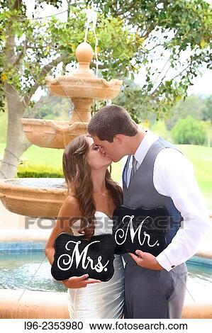 bride and groom kissing, holding 'Mr and Mrs' signs in front of a fountain View Large Photo Image Stock Image - bride and groom kissing, holding 'Mr and Mrs' signs in front of a fountain. Fotosearch